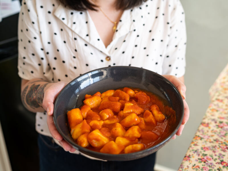holding a bowl of gnocchi