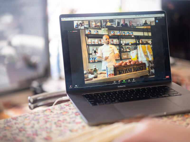 Laptop with Zoom on whilst chef teaches cooking class online. 