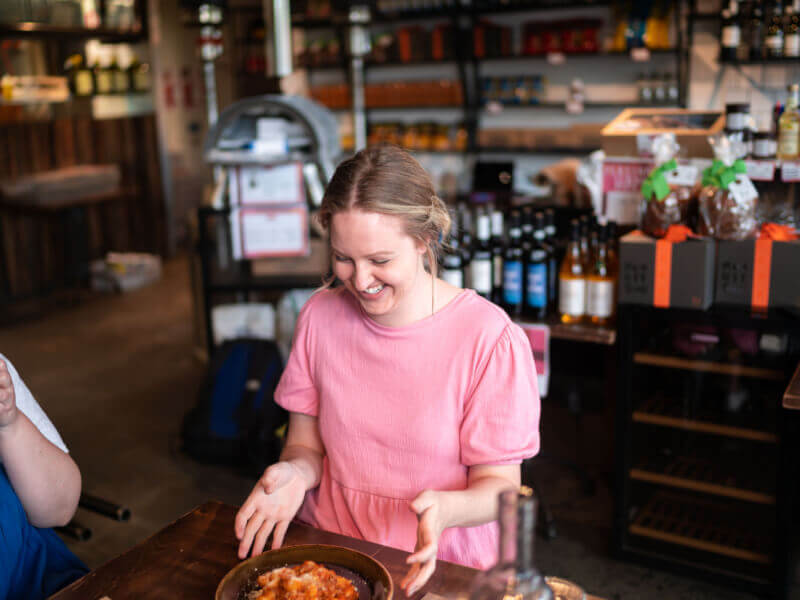 Woman sitting down to enjoy her pasta