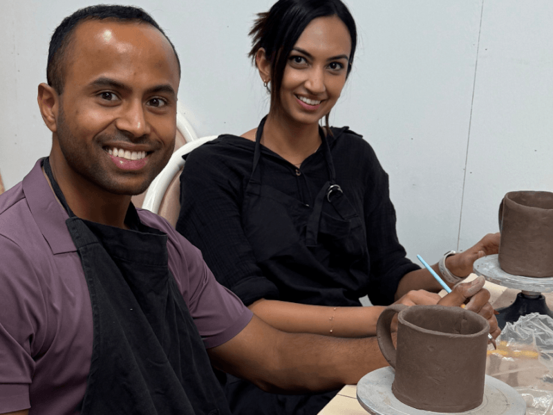 people handmaking a clay mug