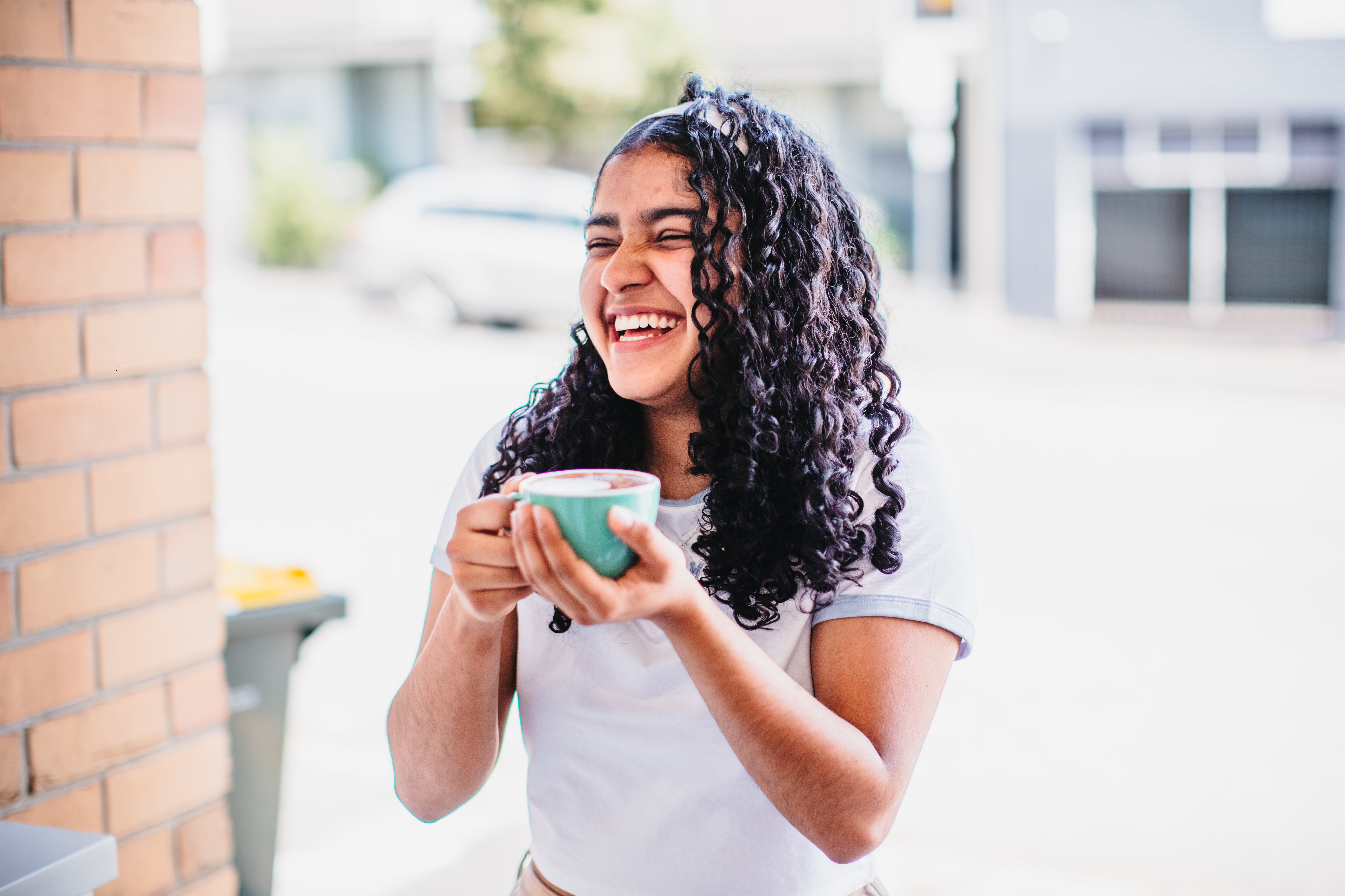 Woman smiling and holding a cup of coffee