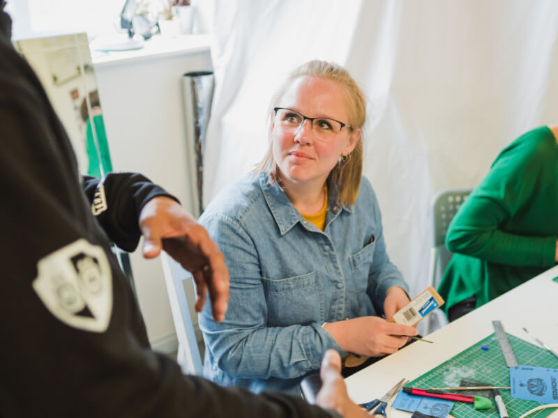 Person looking up at teacher at jewellery making class
