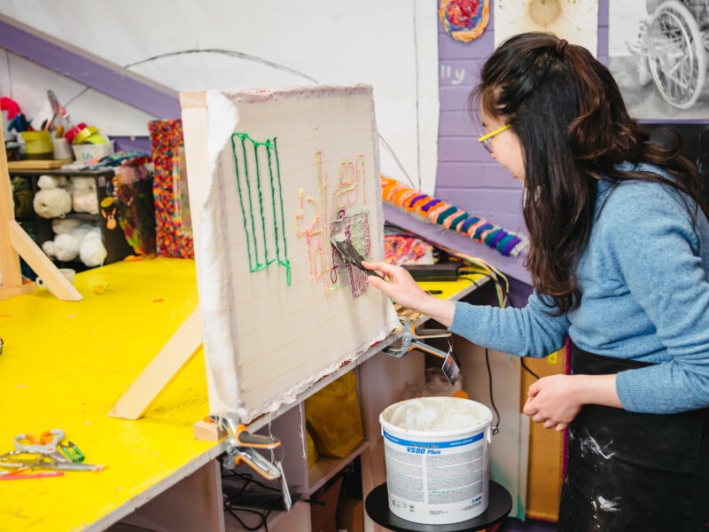 Woman gluing a tufted rug