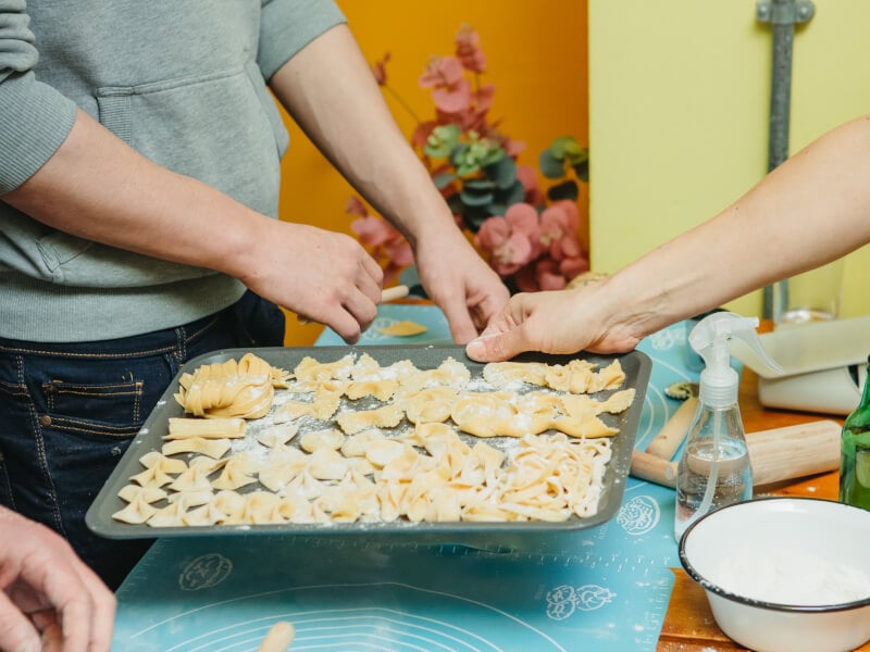 Close-up of person holding a pasta tray