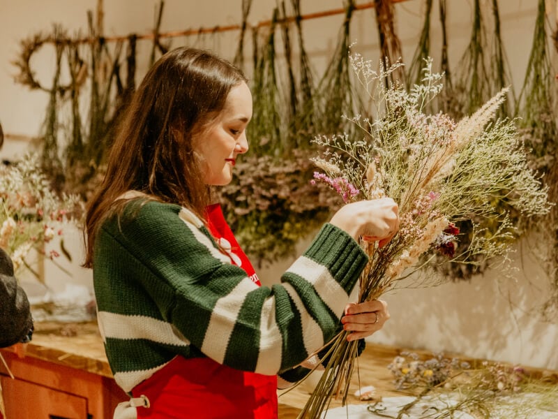 Woman making floral arrangement