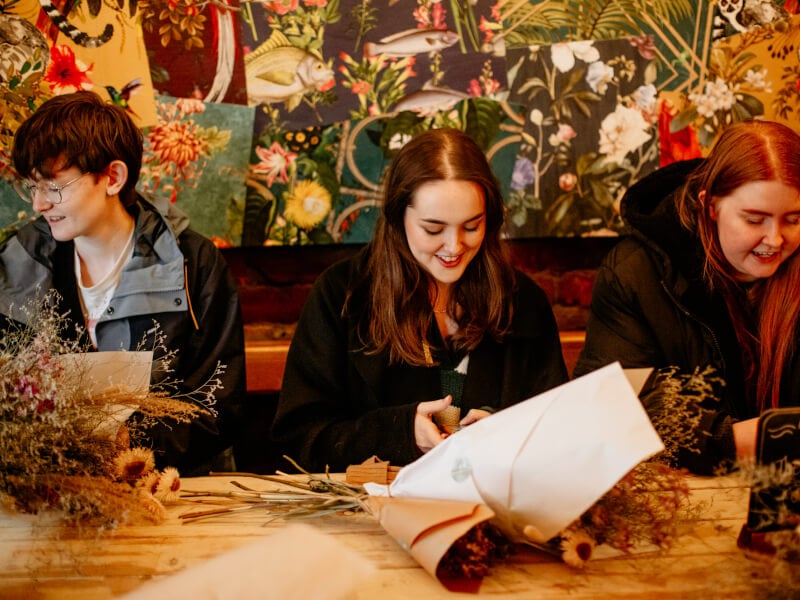 People smiling at a flower arrangement class