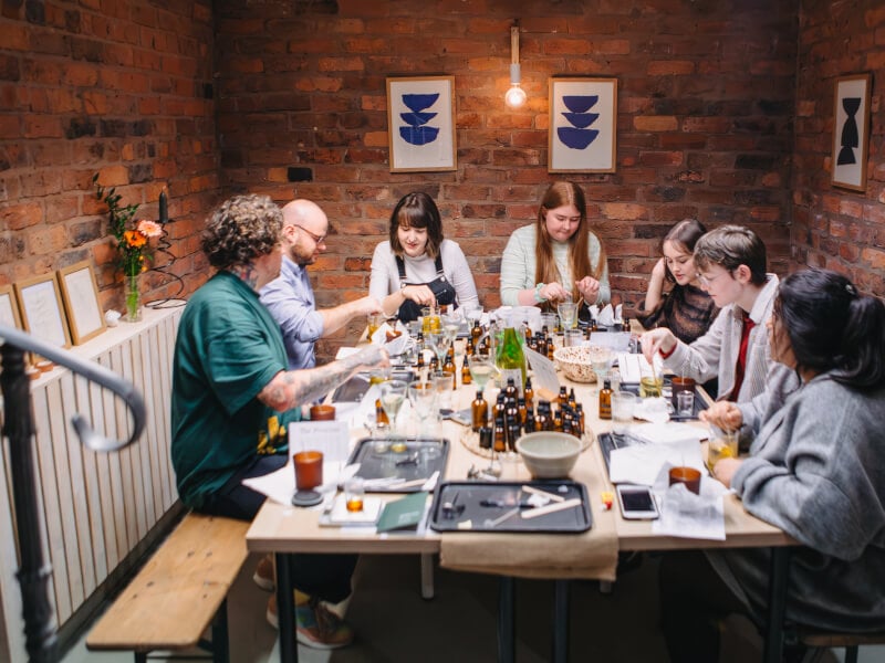 Colleagues sitting around a table making candles