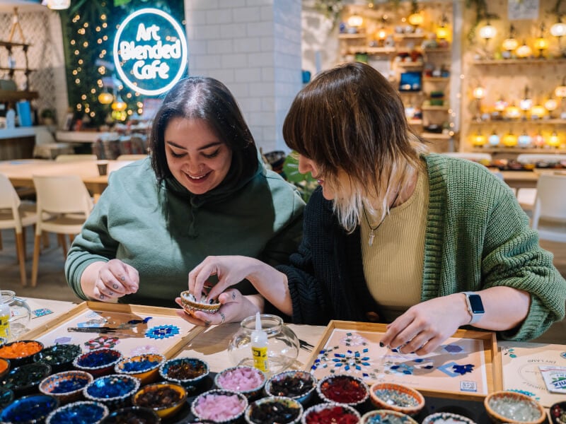 Two women smiling at a craft class.