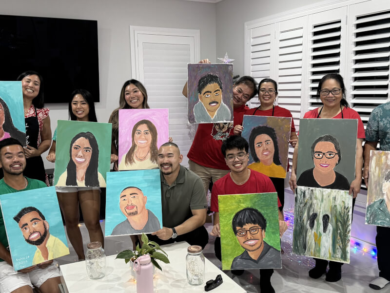 A family pose with their paintings of each other