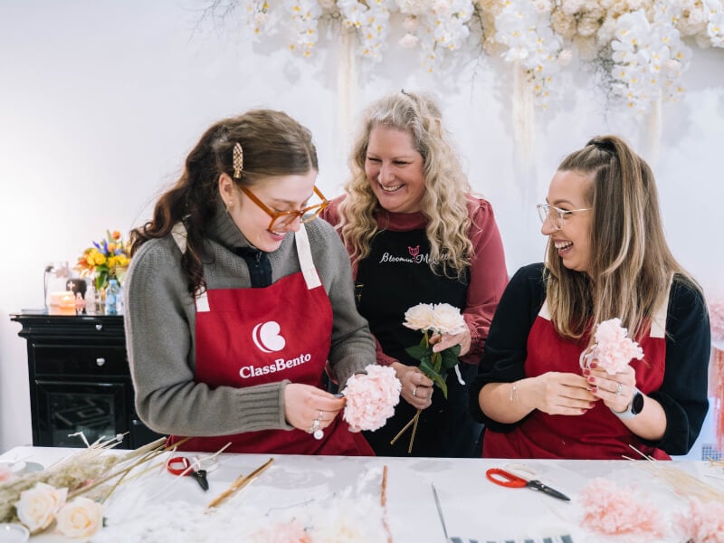 Teacher helping students at a flower arrangement class