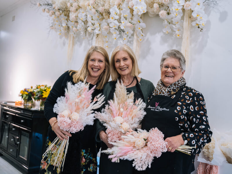 Mother and daughters holding their dried flower arrangements