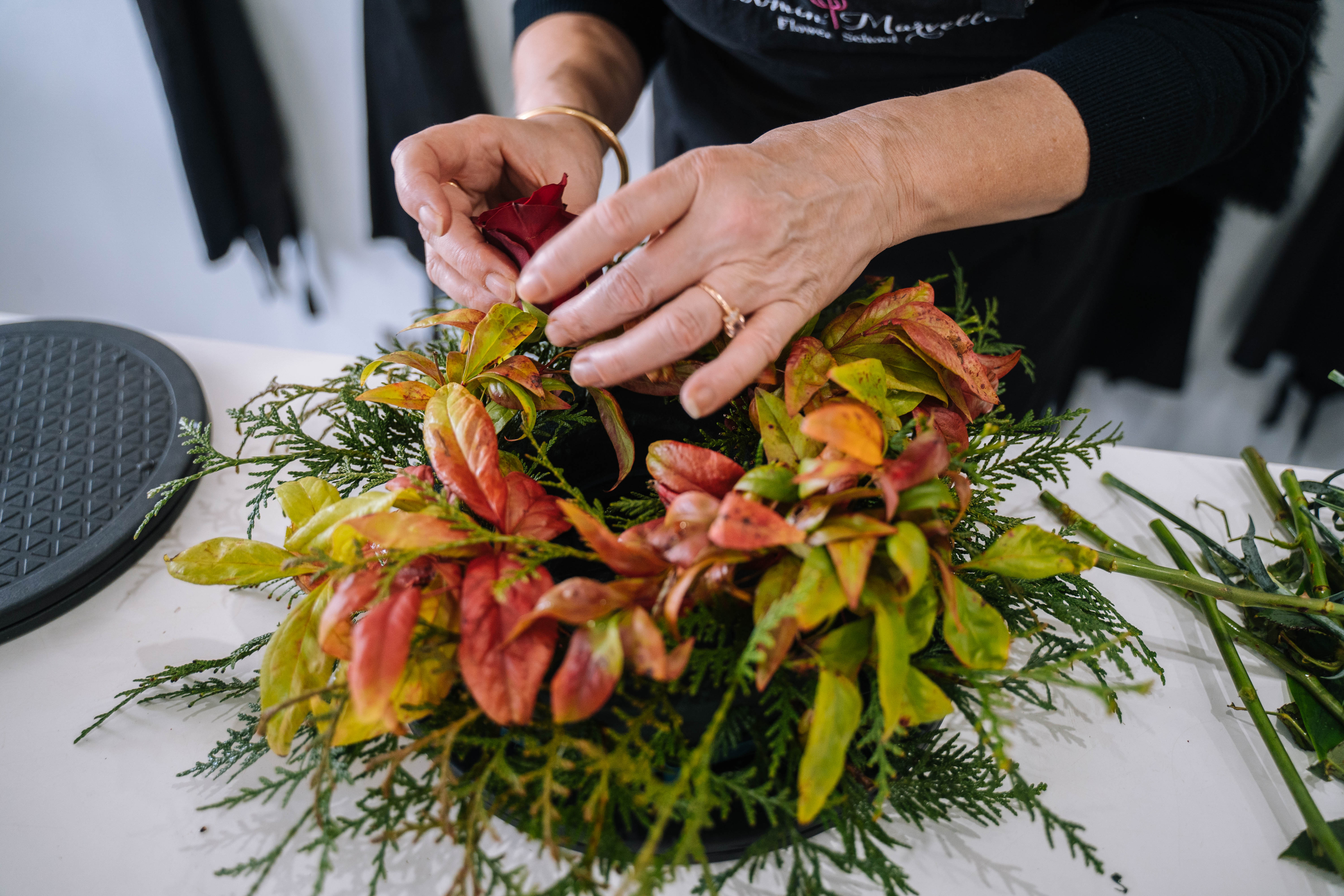 Close-up of woman arranging a Christmas flower arrangement