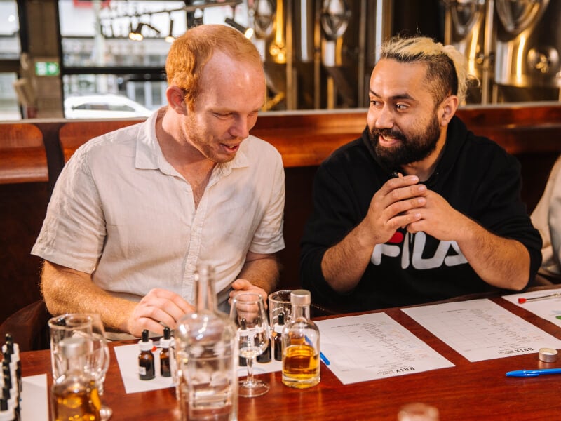 Men talking to each other at a distilling class