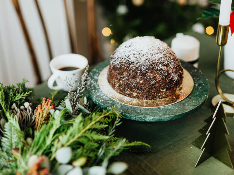 Christmas cake with icing sugar dusting in festive setting