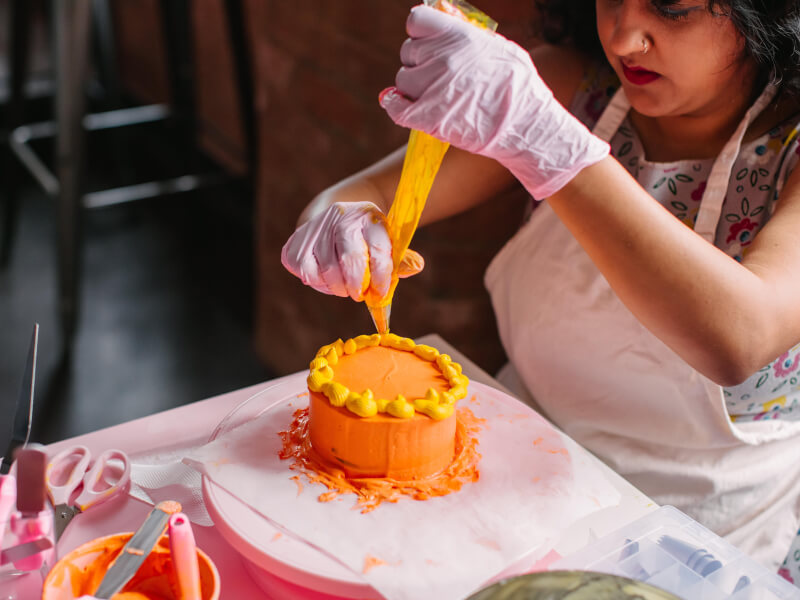 A woman decorating a cake