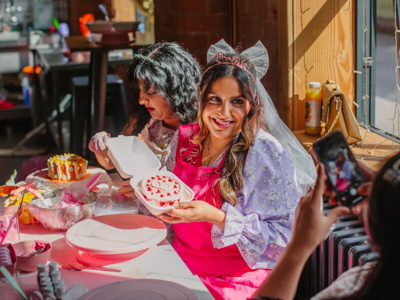 Bride to be holding her decorated cake