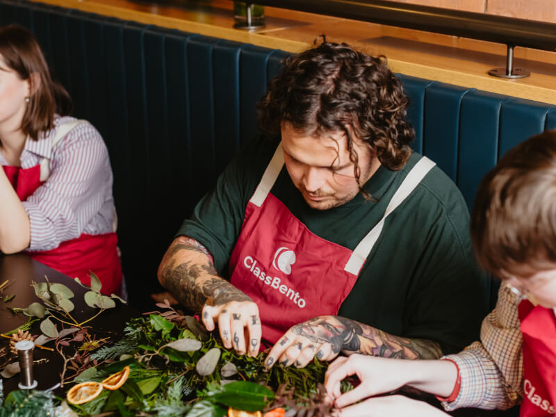 Man concentrating on making a Christmas wreath