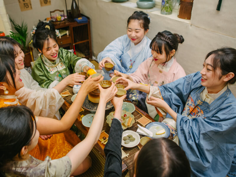 Group of women clinking their tea cups