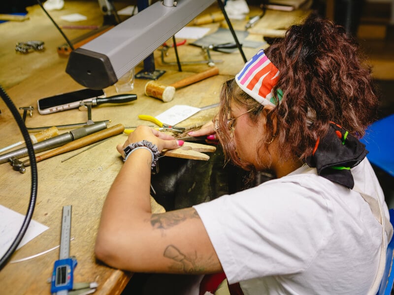 Woman focusing in a jewellery-making workshop