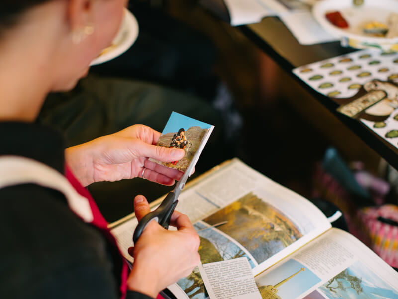 Woman cutting a photo for a collage art class