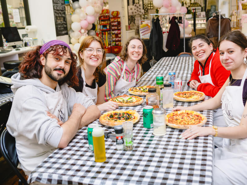 People smiling at a pizza making class