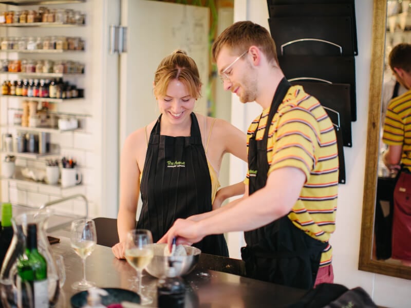 Couple mixing ingredients in a bowl at a cooking class