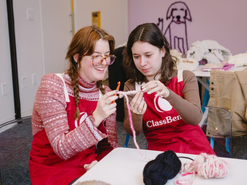 Two women crochet together