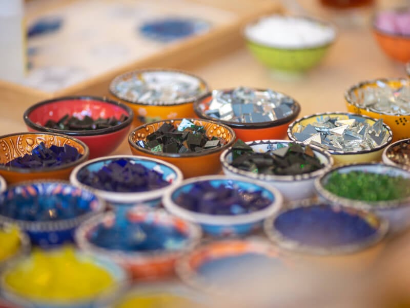 Close-up of small coloured glass pieces in bowls