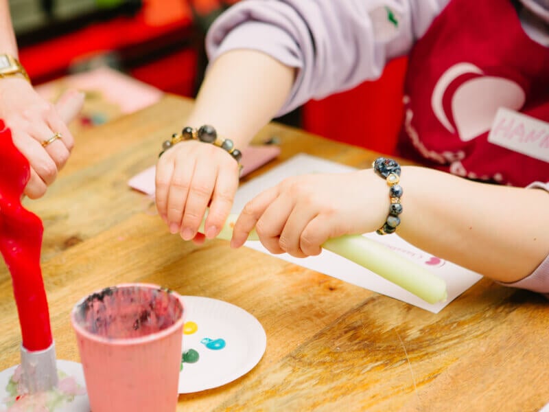 Close-up of someone's hands making colourful candlesticks