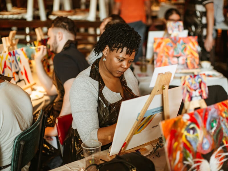 Concentrated woman painting on a canvas