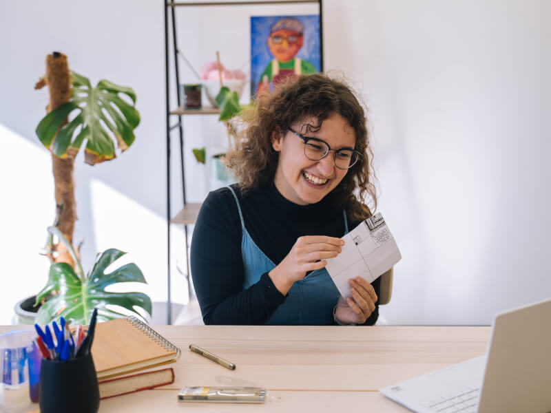 woman smiling with art at online class