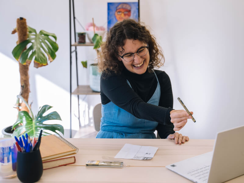 A woman showing her pen to her Zoom class