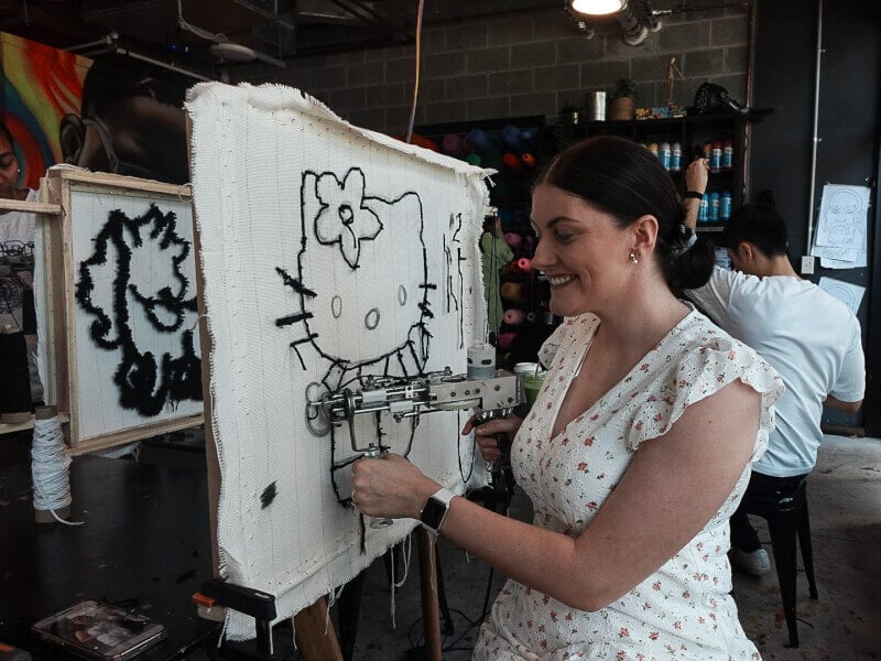 Woman tufting a Hello Kitty design
