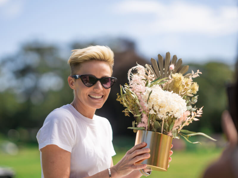 woman posing with dried flower arrangement
