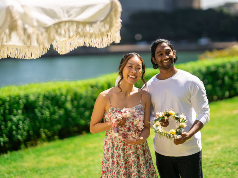 couple posing with flower wreaths