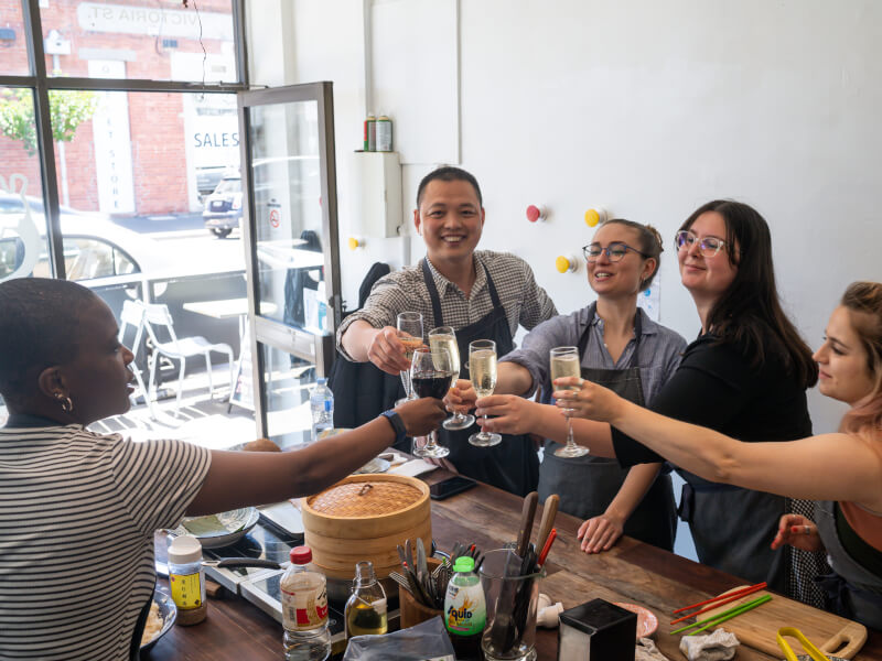 Ha Nguyen and women raise and clink glasses together