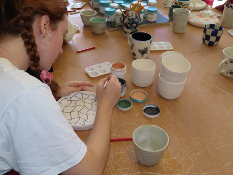 Woman painting pottery