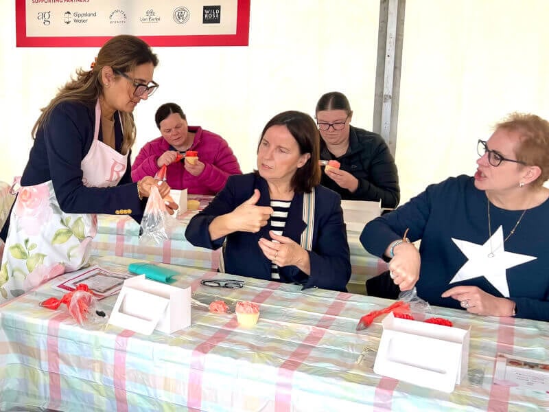 Sonam helping students learn cupcake decorating