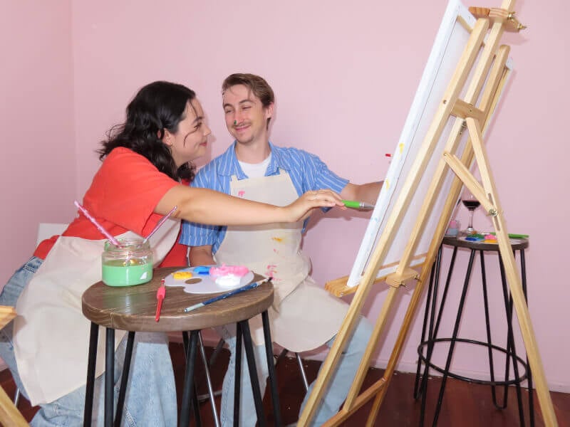 Couple looking at each other while they paint
