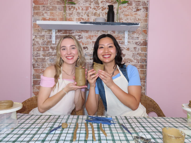 Colleagues holding their finished ceramic cups