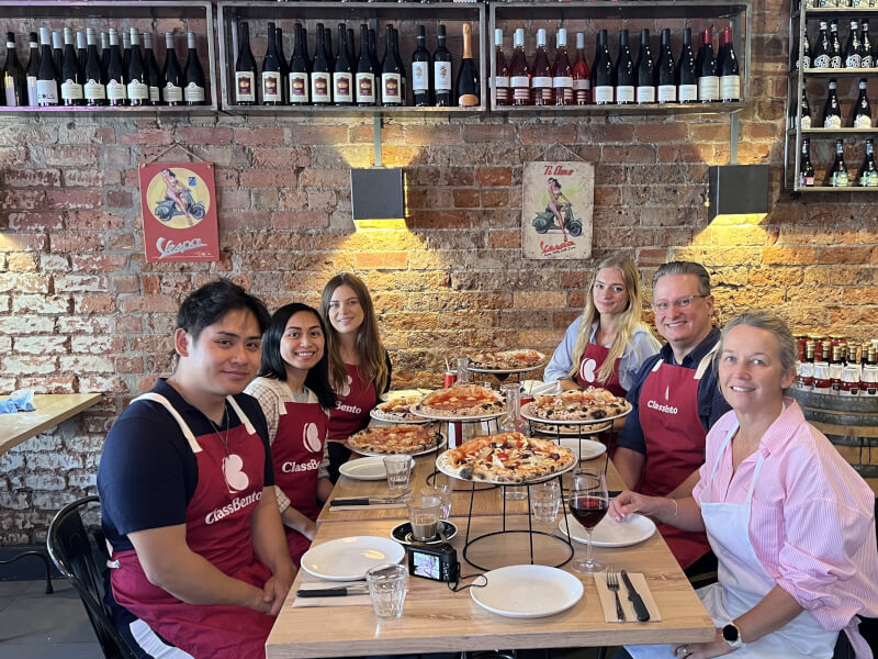 Team smiling at a pizza making class