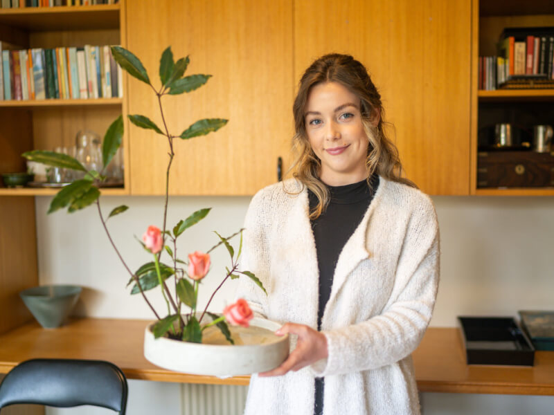 woman smiling with Ikebana arrangement