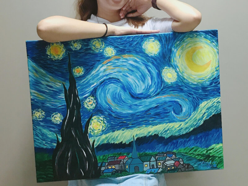 Girl posing with her van gogh starry night artwork at a paint and sip class