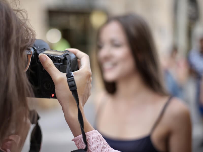 A woman takes photograph of another woman at adults photography class