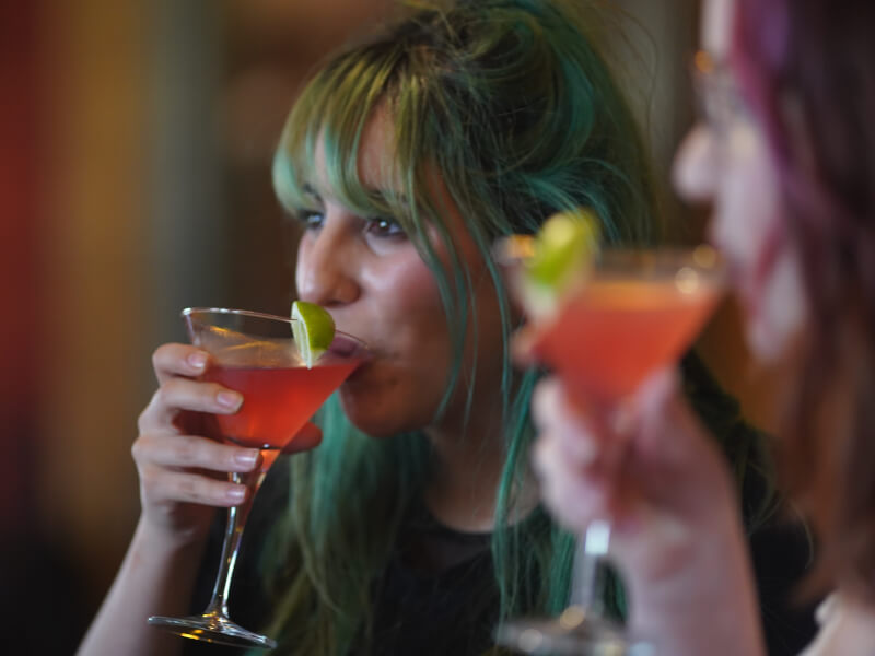 two women sipping cosmopolitan cocktails