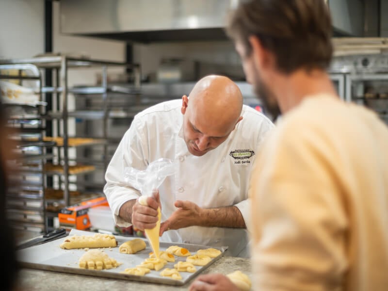 Joel Barda piping filling into unbaked pastry dough