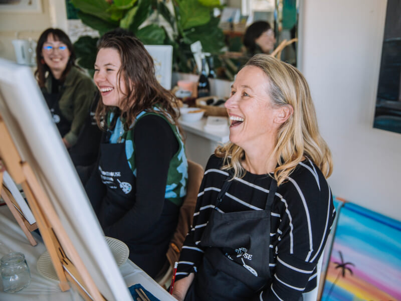Women laughing at a paint and sip class