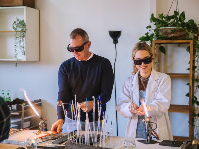 A father and daughter learning about glassblowing together