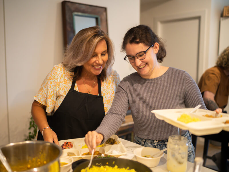 Teacher and student smiling and grabbing food