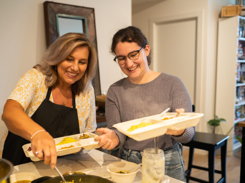 mother and daughter dishing up meals